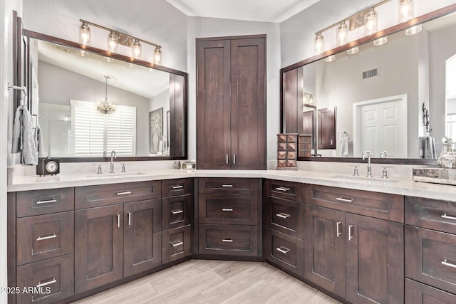 6026 E Sonoran Trl, Scottsdale, AZ 85266 - bathroom featuring lofted ceiling, vanity, wood finished floors, and a chandelier