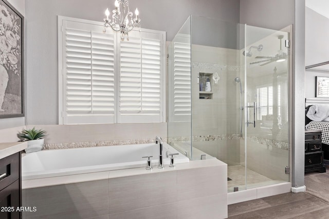 6026 E Sonoran Trl, Scottsdale, AZ 85266 - bathroom with a shower stall, a garden tub, wood finished floors, and a chandelier