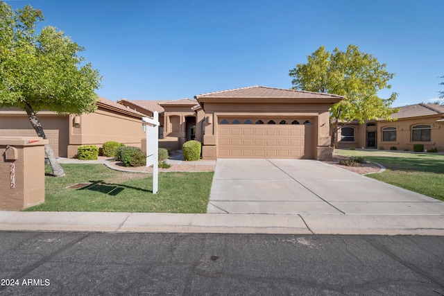 view of front of home featuring a front yard and a garage