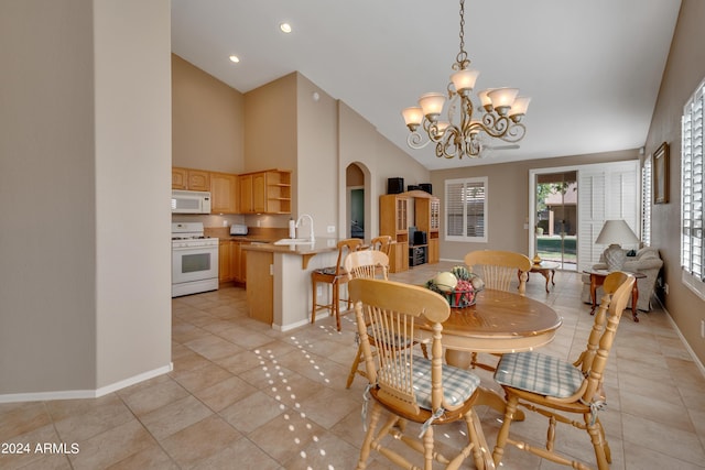 dining space featuring high vaulted ceiling, baseboards, a notable chandelier, arched walkways, and light tile patterned floors