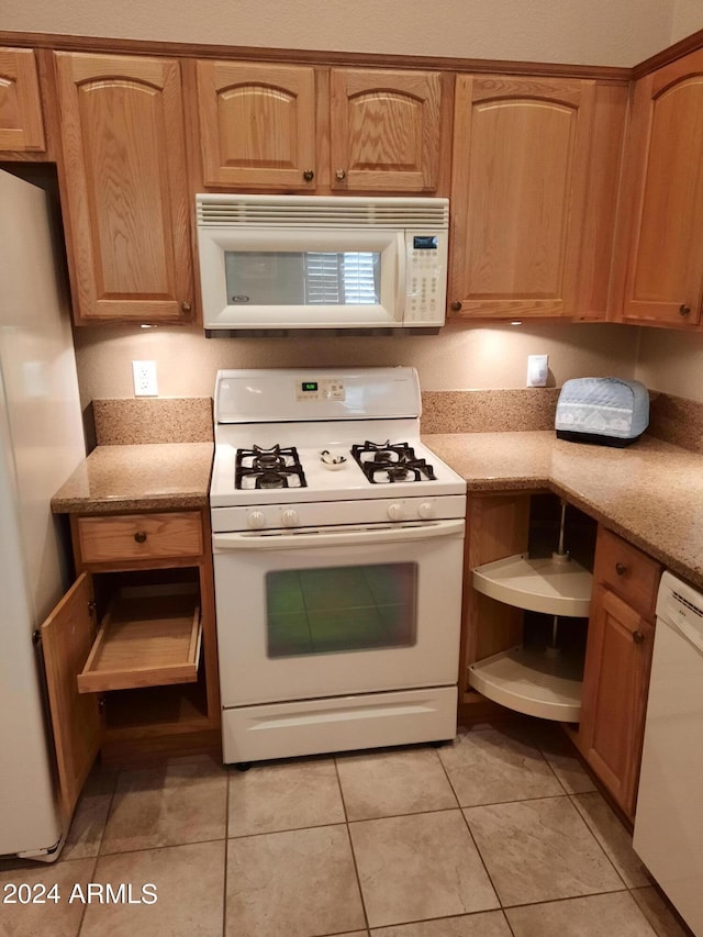 kitchen featuring light tile patterned flooring, white appliances, light stone countertops, and open shelves