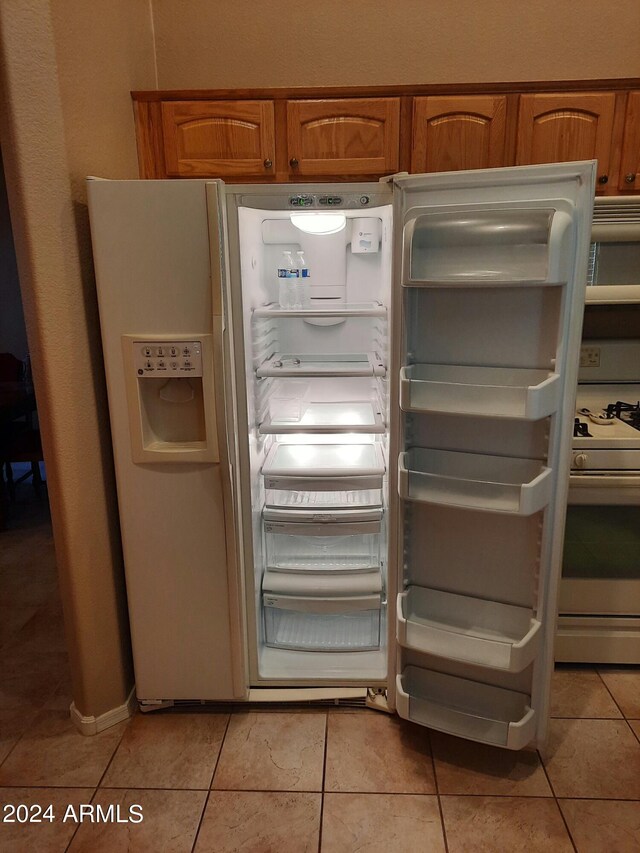 interior details featuring light tile patterned flooring and white appliances