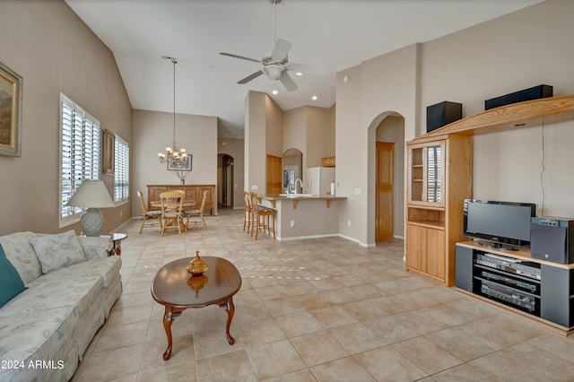 living room featuring light tile patterned floors, high vaulted ceiling, ceiling fan with notable chandelier, baseboards, and arched walkways