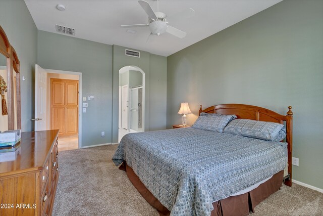 carpeted bedroom featuring ceiling fan and ensuite bath