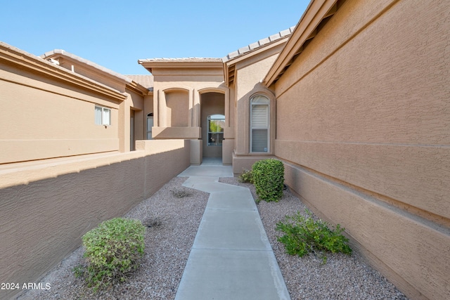 doorway to property with stucco siding and a tile roof