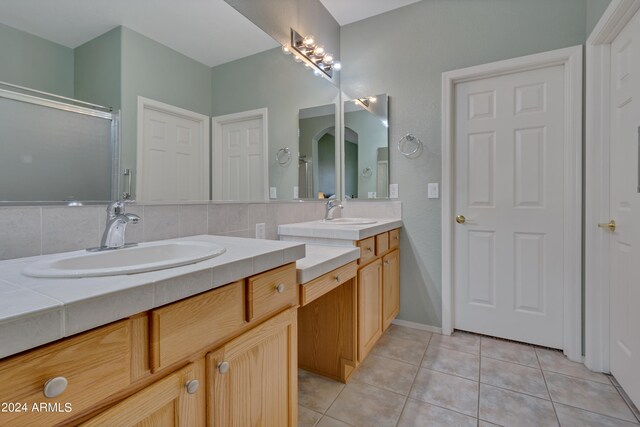 bathroom featuring tile patterned flooring, vanity, and a shower with door