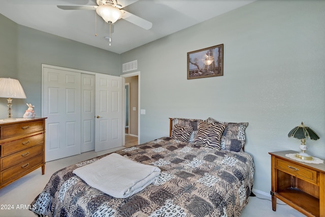 bedroom with a closet, ceiling fan, visible vents, and light carpet