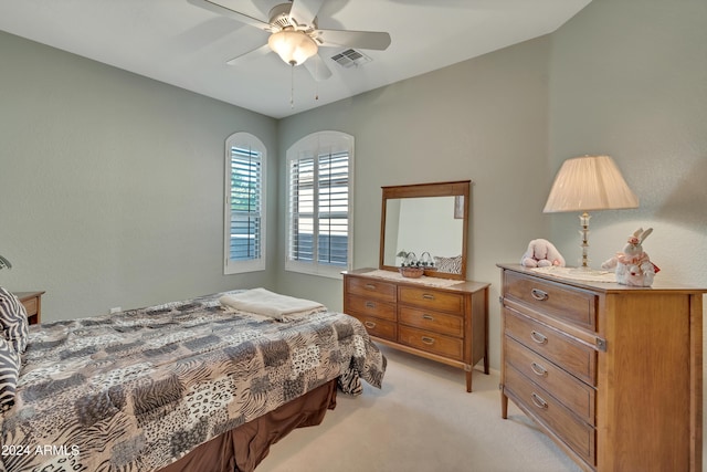 bedroom featuring light carpet, visible vents, and ceiling fan