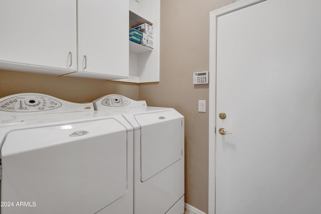 washroom featuring washing machine and clothes dryer and cabinet space