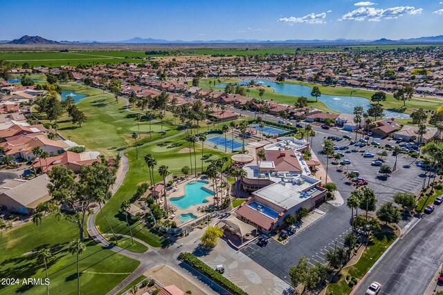 aerial view featuring a water and mountain view, view of golf course, and a residential view