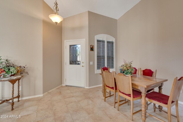 dining space with high vaulted ceiling