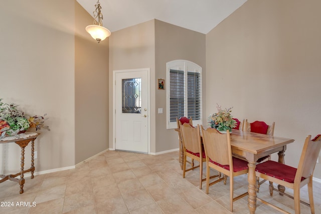 dining space featuring baseboards and vaulted ceiling