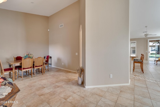 dining room with visible vents, baseboards, a ceiling fan, arched walkways, and light tile patterned floors