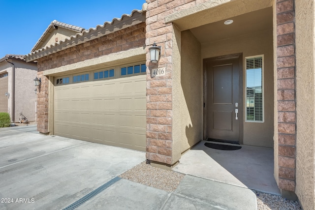 doorway to property with a garage