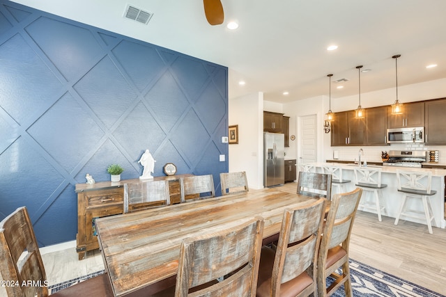 dining room with ceiling fan and light hardwood / wood-style flooring