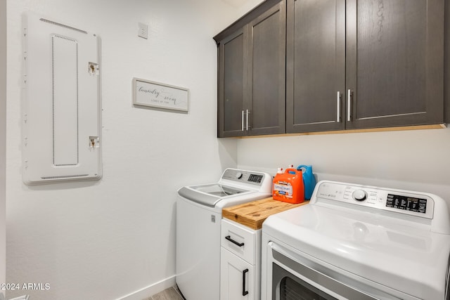 laundry area featuring cabinets, electric panel, and independent washer and dryer