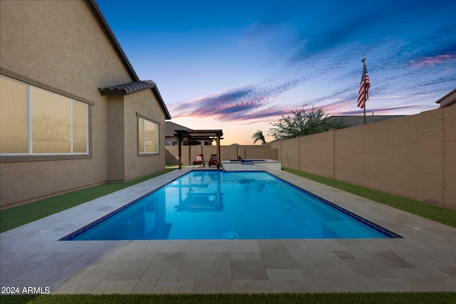 pool at dusk with a patio area