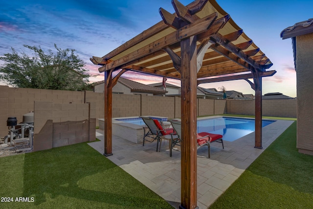 patio terrace at dusk with a lawn and a fenced in pool