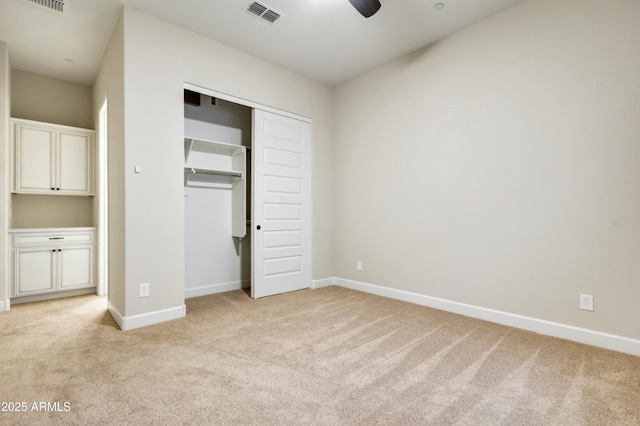 unfurnished bedroom featuring ceiling fan, light carpet, and a closet