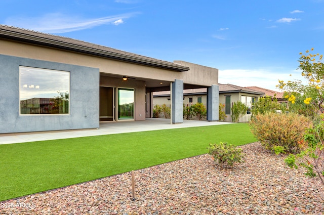 rear view of property featuring a yard and a patio area