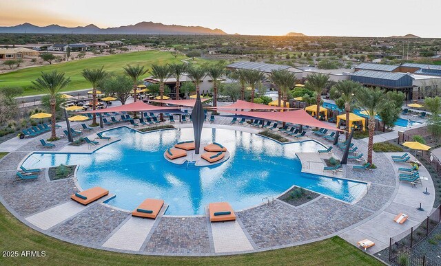 pool at dusk featuring a mountain view