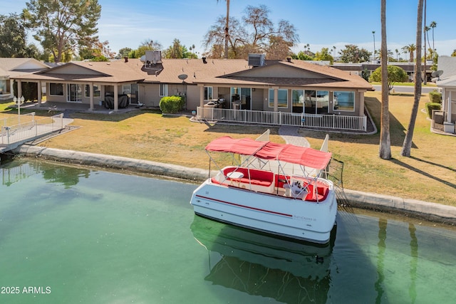 back of property featuring a water view, a lawn, and central air condition unit