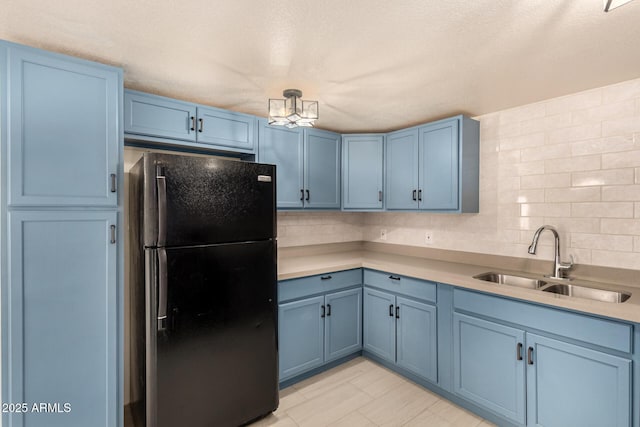 2721 W Luke Ave, Phoenix, AZ 85017 - kitchen with freestanding refrigerator, blue cabinetry, and a sink