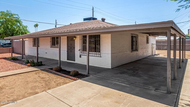 2721 W Luke Ave, Phoenix, AZ 85017 - view of front of home with brick siding, an attached carport, covered porch, concrete driveway, and a shingled roof