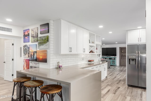 675 Val Verde Cir W, Litchfield Park, AZ 85340 - kitchen with stainless steel fridge, open shelves, a peninsula, decorative backsplash, and white cabinets