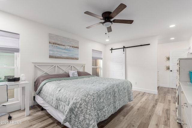 675 Val Verde Cir W, Litchfield Park, AZ 85340 - bedroom featuring a barn door, light wood-type flooring, recessed lighting, a ceiling fan, and baseboards