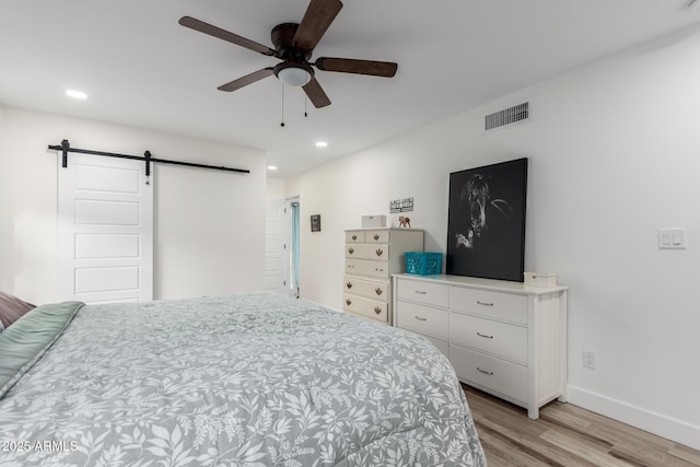 675 Val Verde Cir W, Litchfield Park, AZ 85340 - bedroom with light wood-style flooring, a barn door, recessed lighting, baseboards, and a ceiling fan