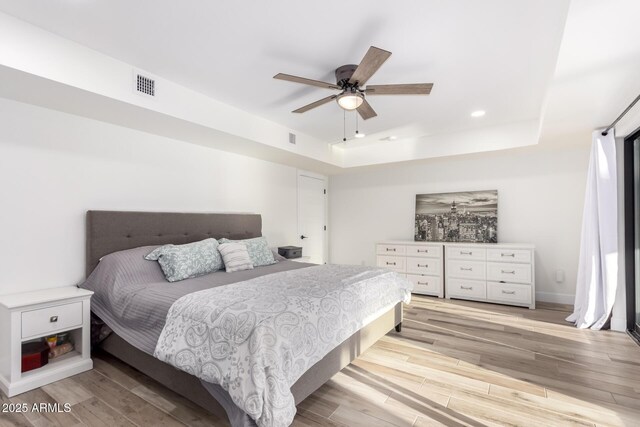 675 Val Verde Cir W, Litchfield Park, AZ 85340 - bedroom featuring a raised ceiling, light wood finished floors, recessed lighting, and ceiling fan