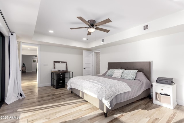 675 Val Verde Cir W, Litchfield Park, AZ 85340 - bedroom with recessed lighting, light wood-style floors, a tray ceiling, baseboards, and a ceiling fan