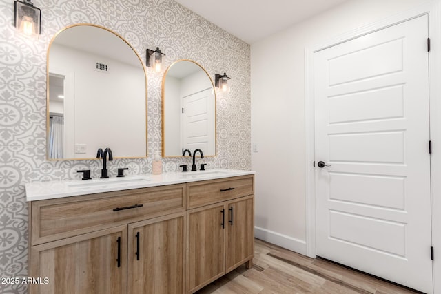 675 Val Verde Cir W, Litchfield Park, AZ 85340 - full bath featuring wallpapered walls, wood finished floors, double vanity, and baseboards