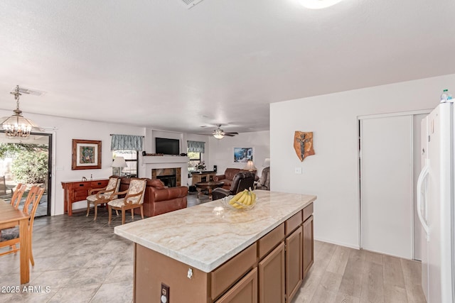 3018 W Country Club Ter, Phoenix, AZ 85027 - kitchen featuring freestanding refrigerator, a fireplace, ceiling fan, light countertops, and a kitchen island