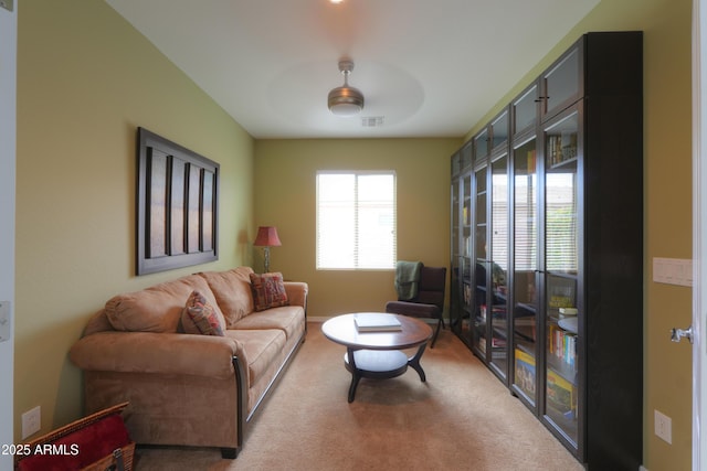 carpeted living room featuring visible vents and a ceiling fan