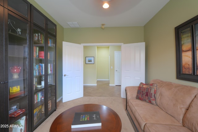 living room with visible vents, light carpet, and baseboards