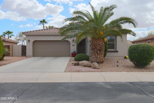 view of front of property featuring a garage, fence, a tile roof, driveway, and stucco siding