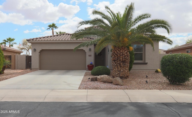 view of front of home featuring driveway, an attached garage, a tile roof, and stucco siding