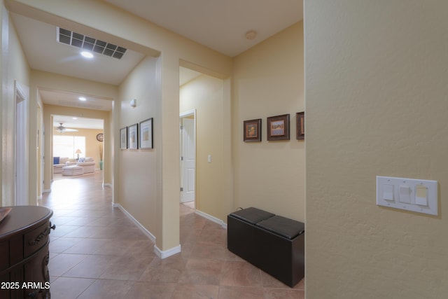 hall featuring visible vents, baseboards, and tile patterned floors