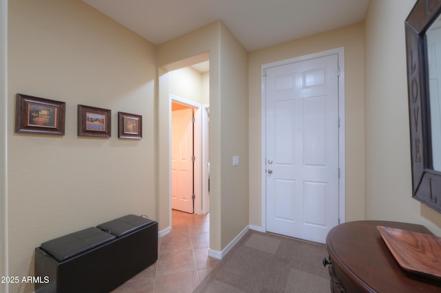 entryway with baseboards and light tile patterned flooring