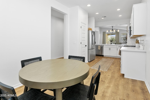 dining space featuring light hardwood / wood-style flooring and a chandelier