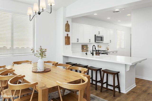 dining room with dark wood-type flooring and a chandelier