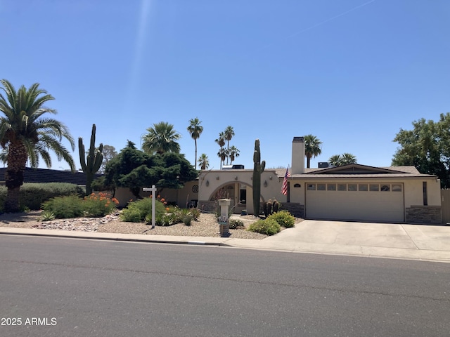 2125 E Elmwood St, Mesa, AZ 85213 - view of front of property with stucco siding, a garage, driveway, and stone siding