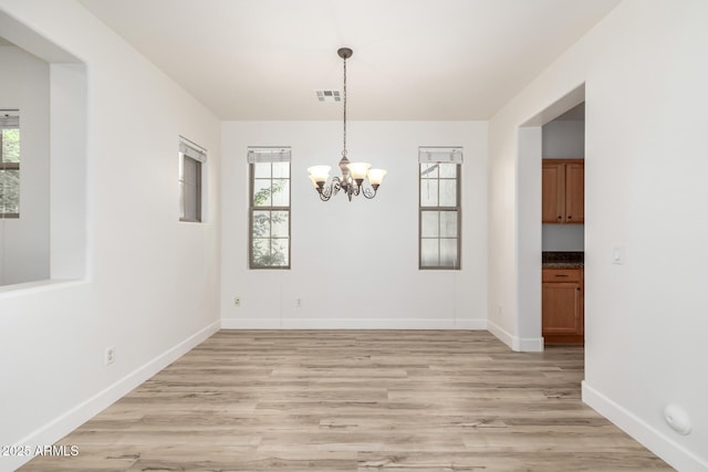 15469 W Dreyfus St, Surprise, AZ 85379 - unfurnished dining area featuring plenty of natural light, light wood finished floors, and a chandelier