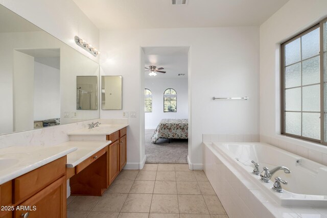 15469 W Dreyfus St, Surprise, AZ 85379 - ensuite bathroom with double vanity, a bath, a ceiling fan, tile patterned floors, and baseboards