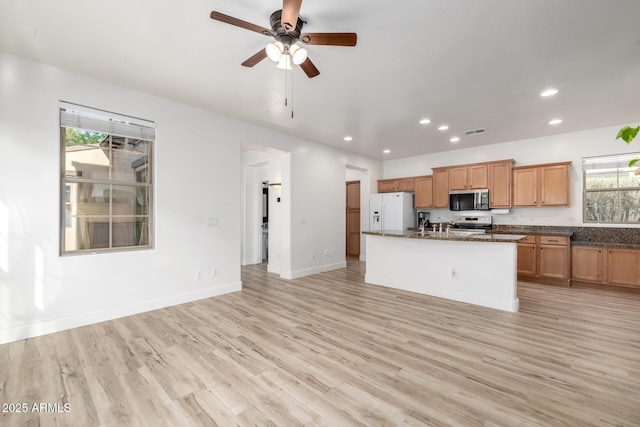 15469 W Dreyfus St, Surprise, AZ 85379 - kitchen featuring stainless steel appliances, recessed lighting, light wood finished floors, healthy amount of natural light, and an island with sink