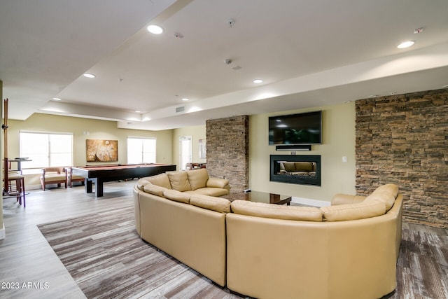 living room with a tray ceiling, hardwood / wood-style flooring, billiards, and a healthy amount of sunlight