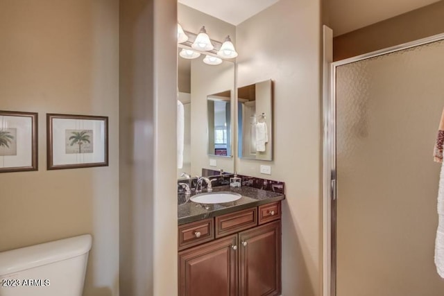 bathroom with vanity, a shower with shower door, and toilet