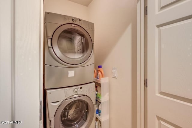 clothes washing area featuring stacked washing maching and dryer